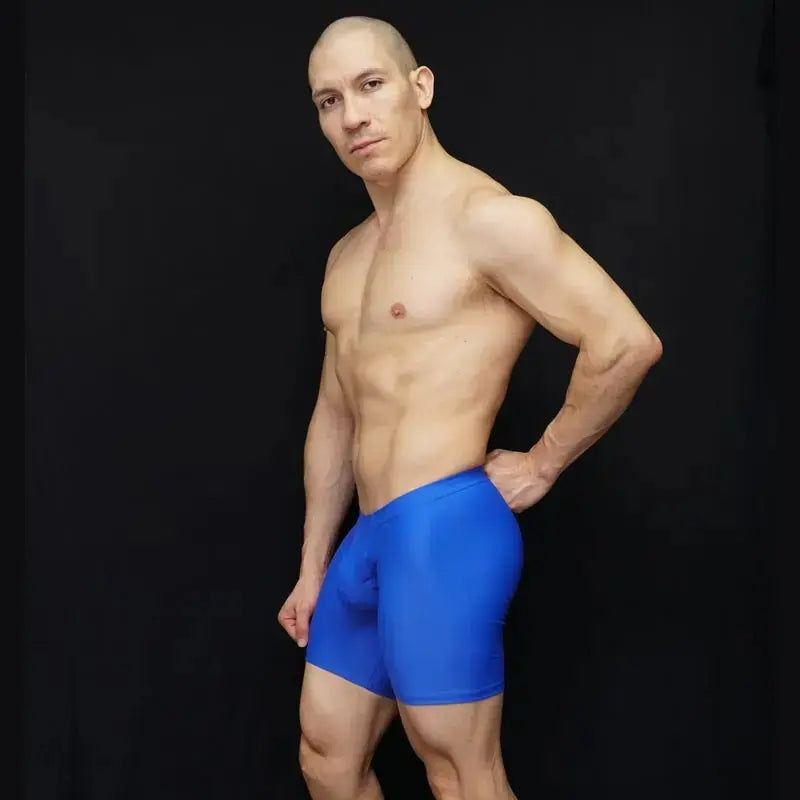 Blue athletic biker shorts made of stretchy material shown on a model against a black background by Arroyman