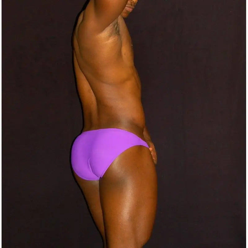 Men's purple bikini underwear by Arroyman featuring a snug fit and smooth fabric shown on a model from the side.