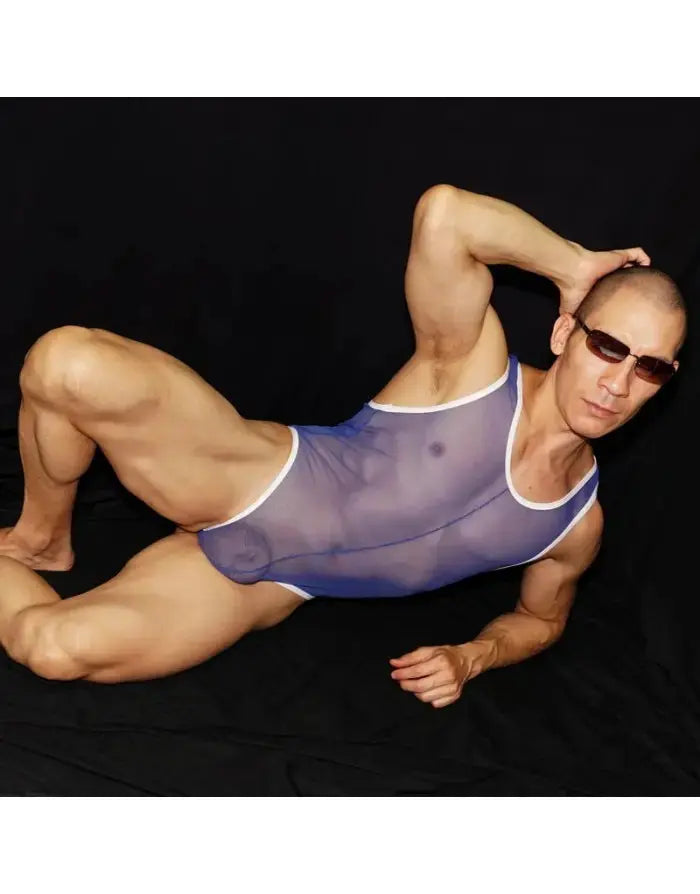 Men's blue sheer bodysuit thong with white trim modeled by a man wearing sunglasses by Arroyman.