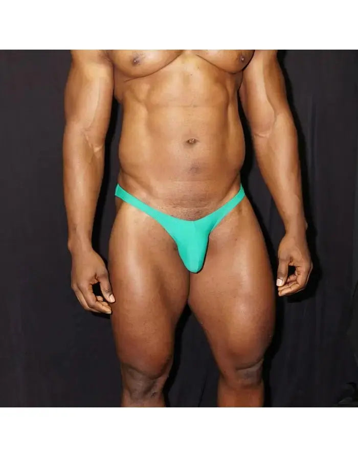 Green men's bodybuilding bikini by Arroyman featuring a minimal design and elastic waistband shown on a model.