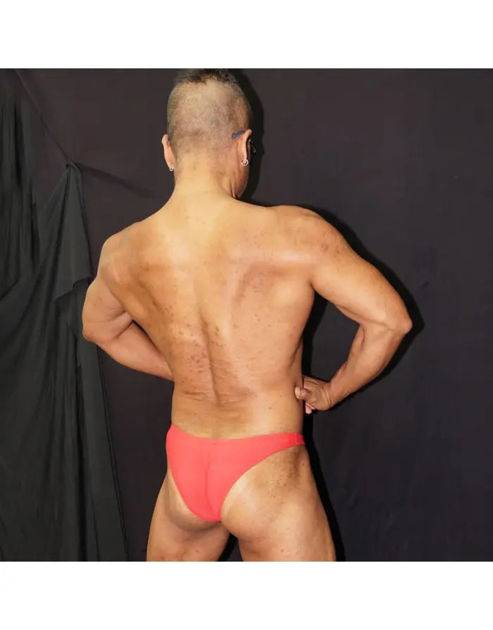Red micro bikini underwear by Arroyman featuring a minimal coverage design shown on a model from the back.