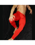 Red men's tights made of stretchy material featuring a bulge-enhancing design shown on a model by Arroyman.