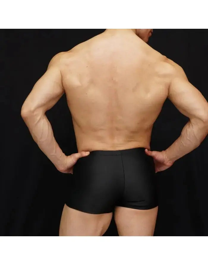 Black men's boxer swim shorts by Arroyman featuring a snug fit and smooth material shown from the back on a model.