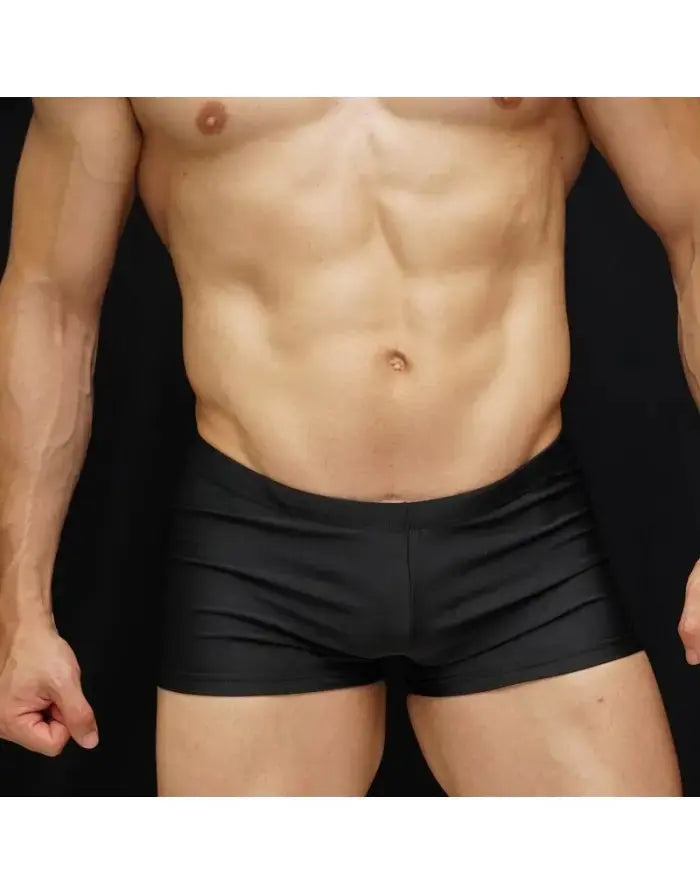 Black men's boxer swim shorts made of smooth material shown on a model with a muscular build by Arroyman.
