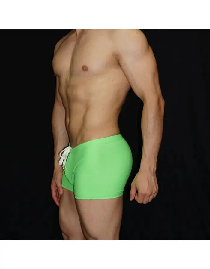 Fluor green square cut boxer swimwear by Arroyman featuring a drawstring waistband and a fitted design shown on a model.