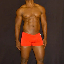 Red square-cut swim trunks by Arroyman featuring a snug fit and smooth fabric modeled by a male model.