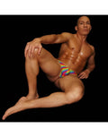 Arroyman men's rainbow tie-dye thong underwear worn by a seated male model.