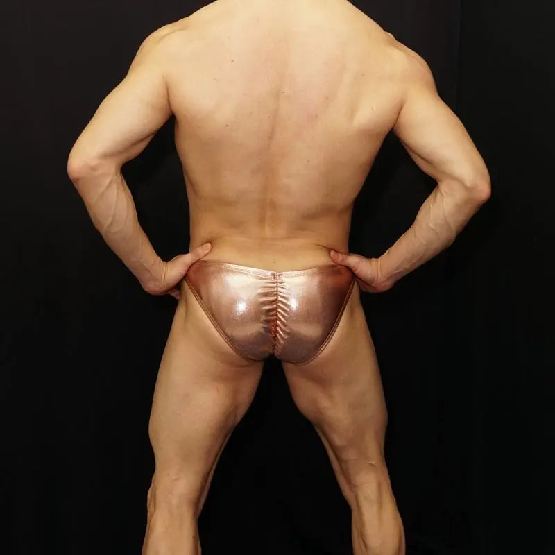 Men's copper bikini underwear by Arroyman featuring a shiny finish and unique back design worn by a model.