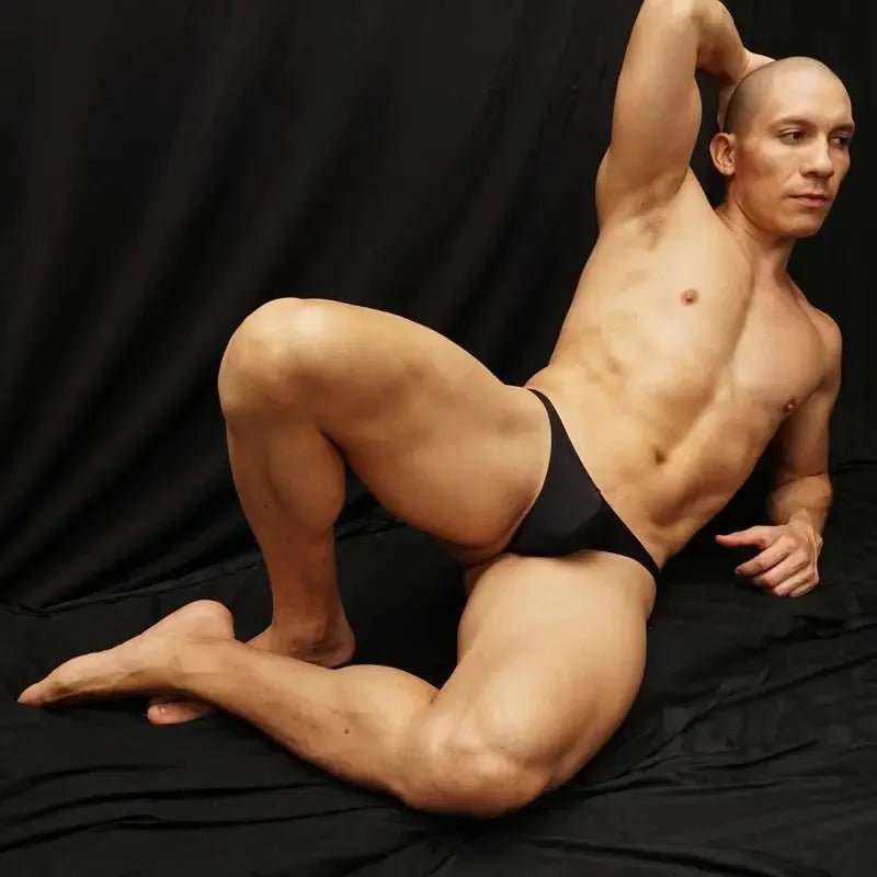 Black thong underwear by Arroyman featuring a minimal design shown on a model against a dark background.