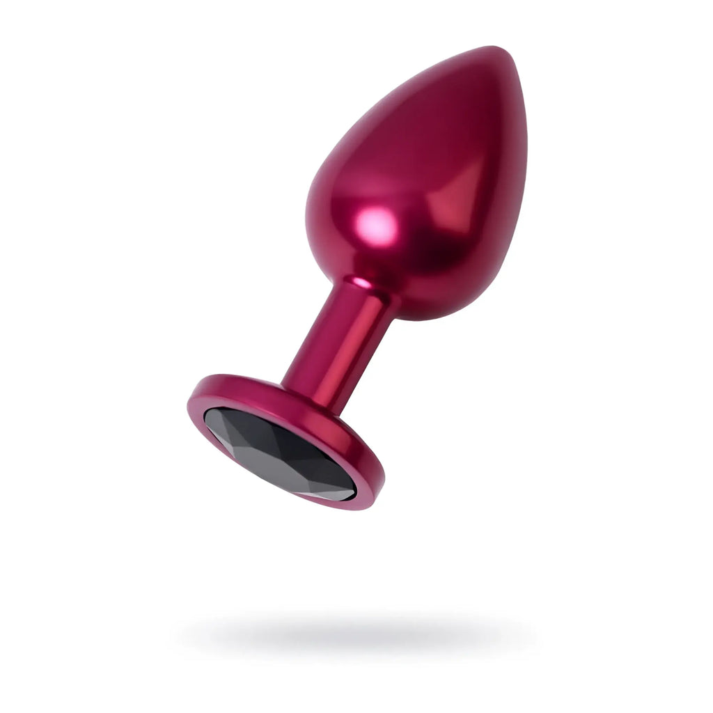 A sleek metallic magenta metal anal plug with a faceted black crystal gemstone embedded at its base