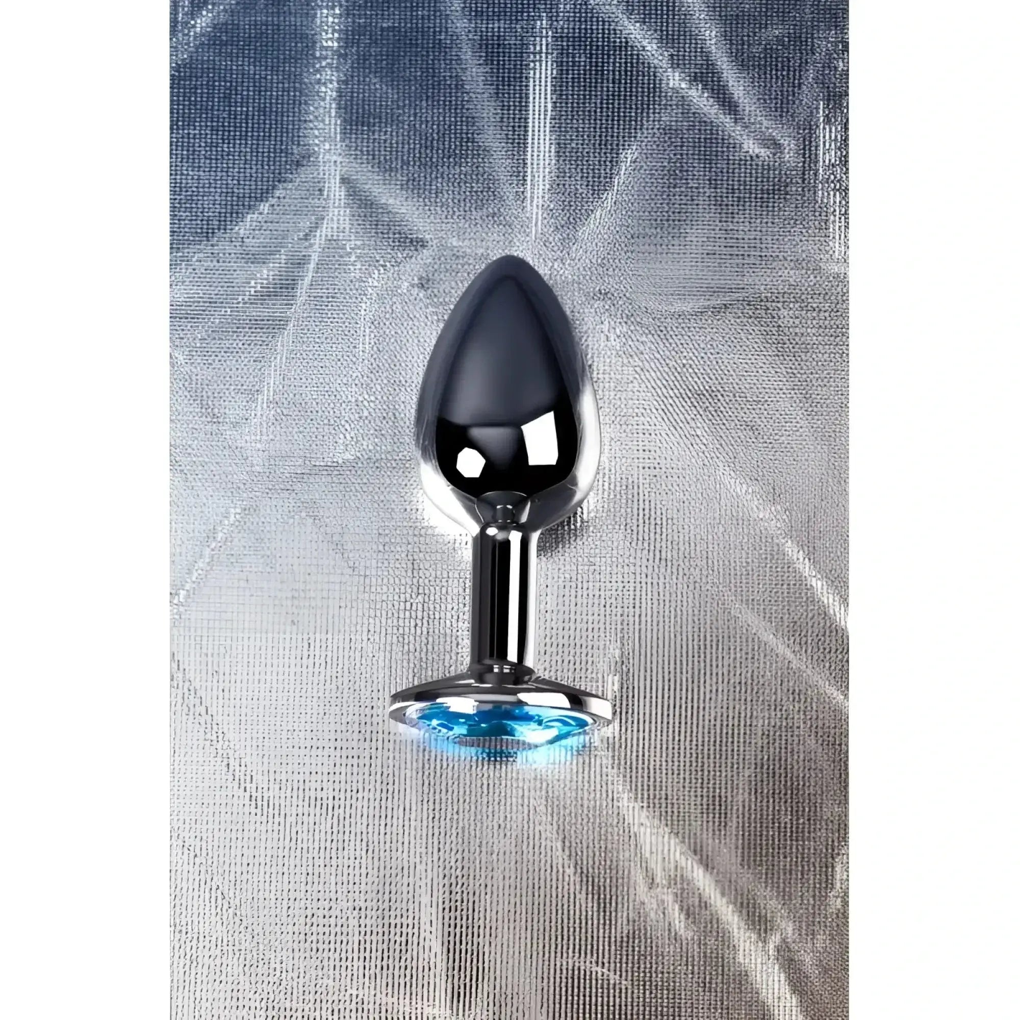 Small shiny chrome-plated metal silver anal plug with a faceted blue topaz crystal accent at the base