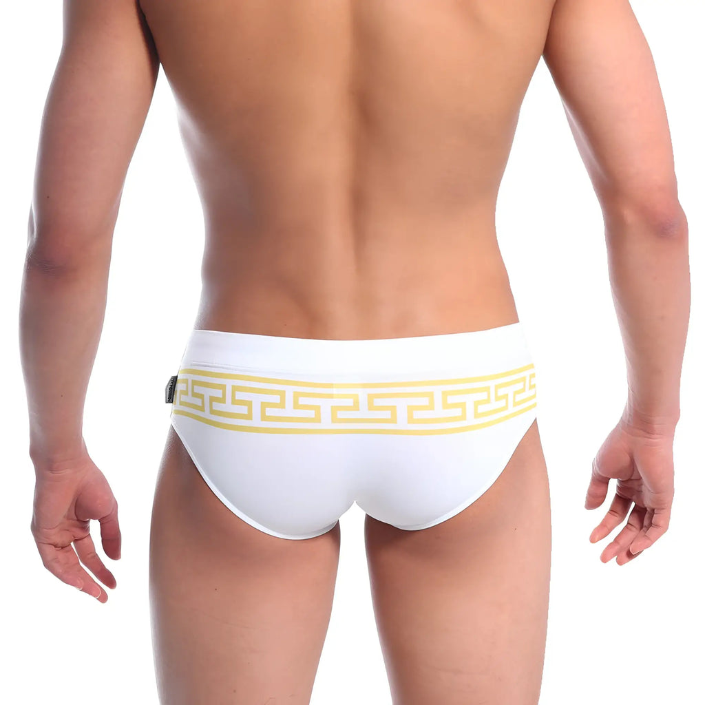 White swim trunks by metromalewear featuring a bold yellow greek key pattern along the waistband
