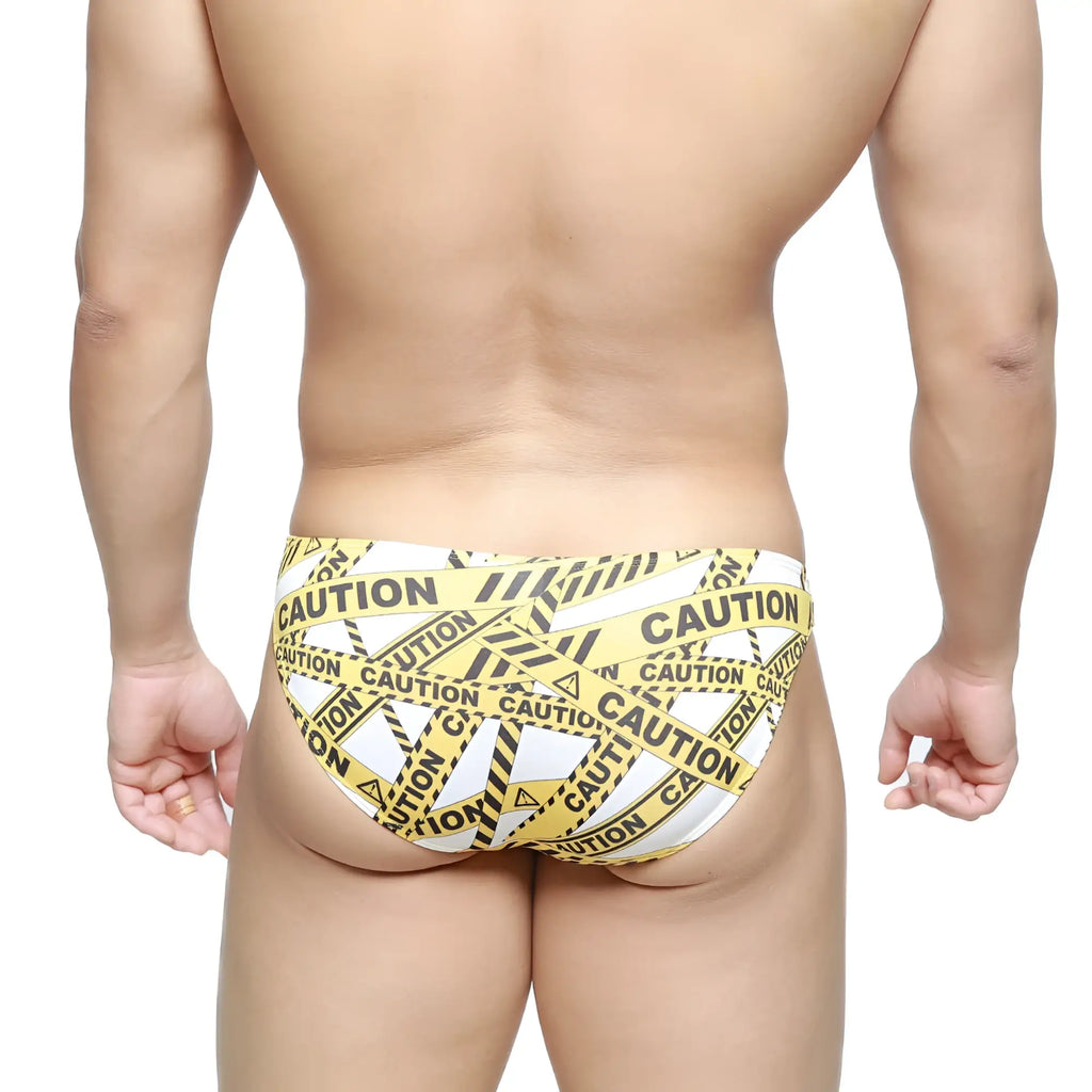 MetroMaleWear caution lowrise bikini swim trunks with yellow and black caution tape pattern in white material