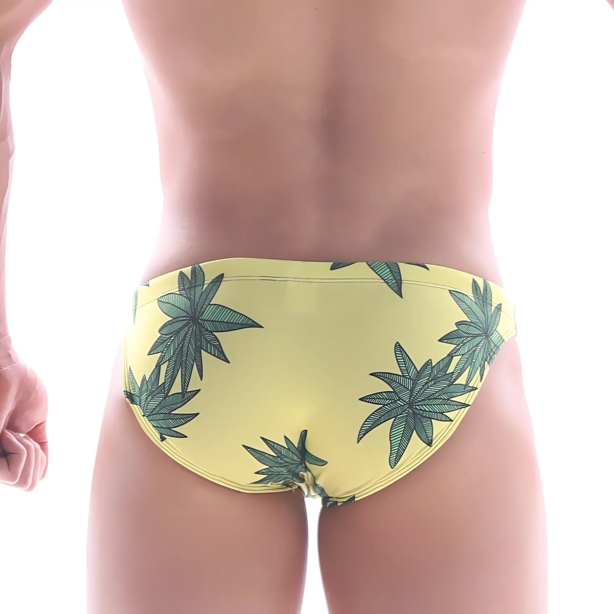 Yellow swim trunks by MetroMaleWear featuring a green cannabis leaf pattern in a classic bikini style