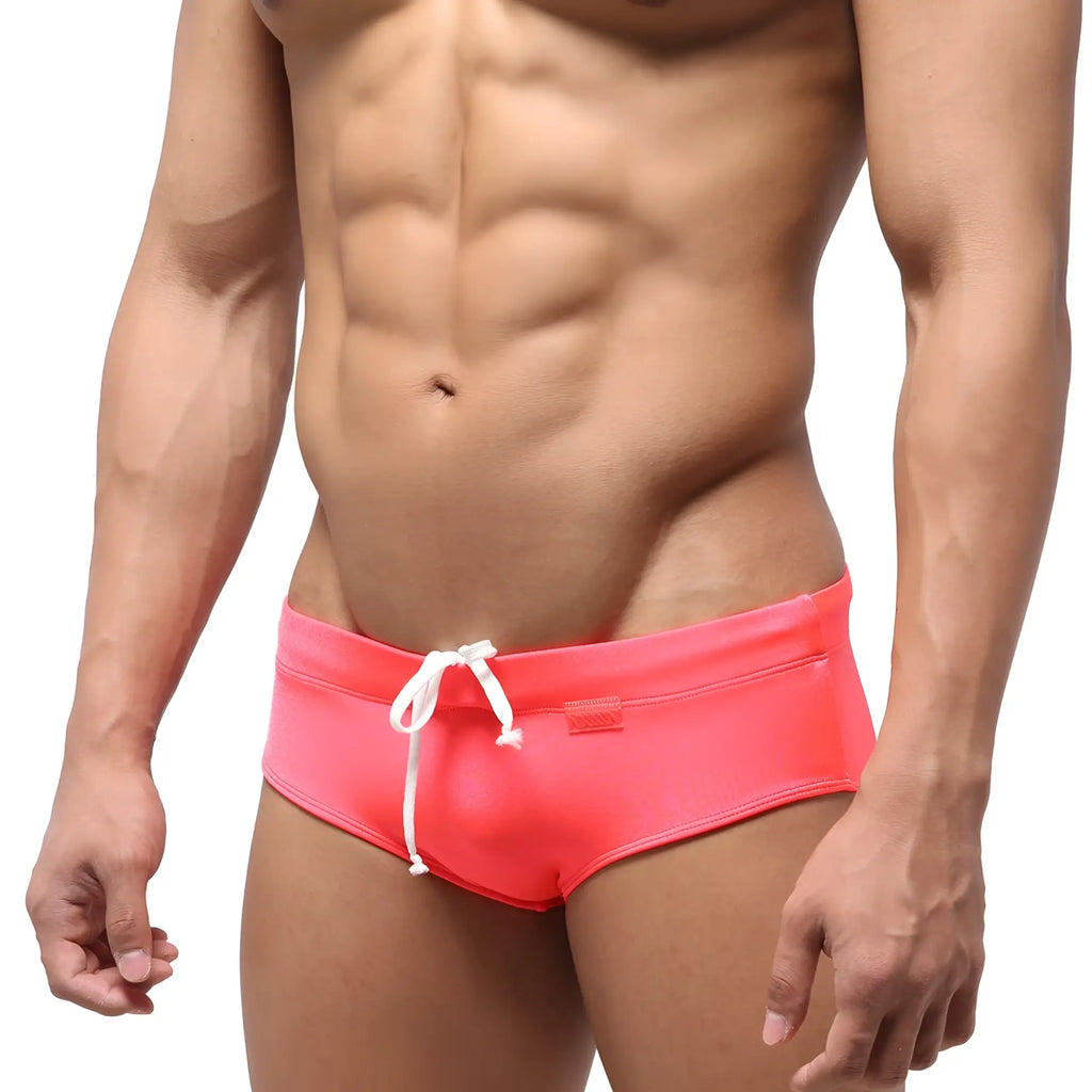 Bright pink metroMalewear classic swim brief with white drawstrings and brand tag on waistband for swimming