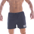 Black athletic MetroMaleWear flexible swim trunks with drawstring waistband and white logo patch on lower right leg