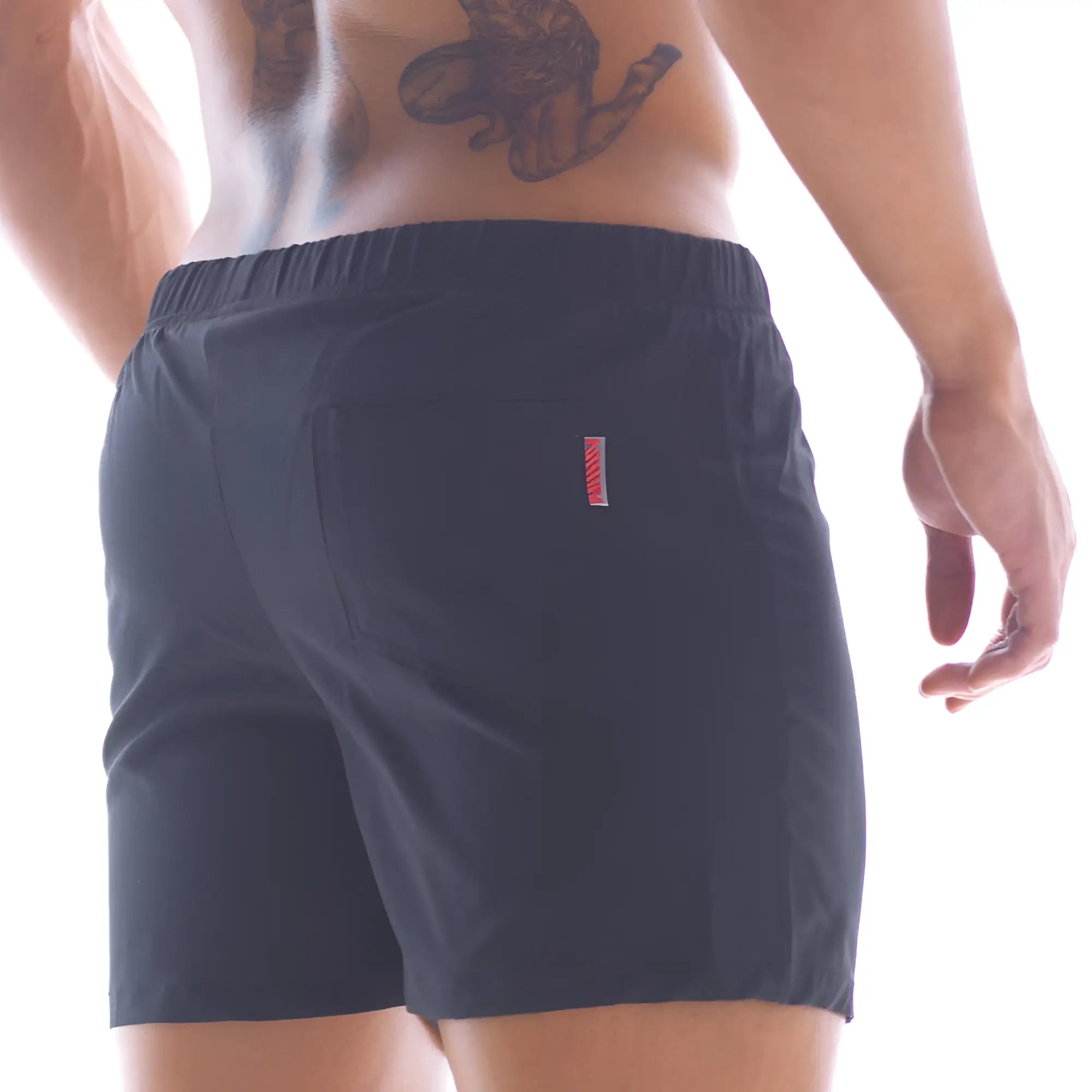 Back side of dark navy metroMalewear flexible swim trunk with subtle red and white vertical stripe on back pocket