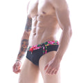 Black MetroMaleWear Flora swim brief featuring vibrant colorful floral pattern on waistband and side panels
