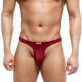 A sleek deep red metroMalewear fria men’s thong made of smooth stretchy fabric with a white brand tag at the waistband