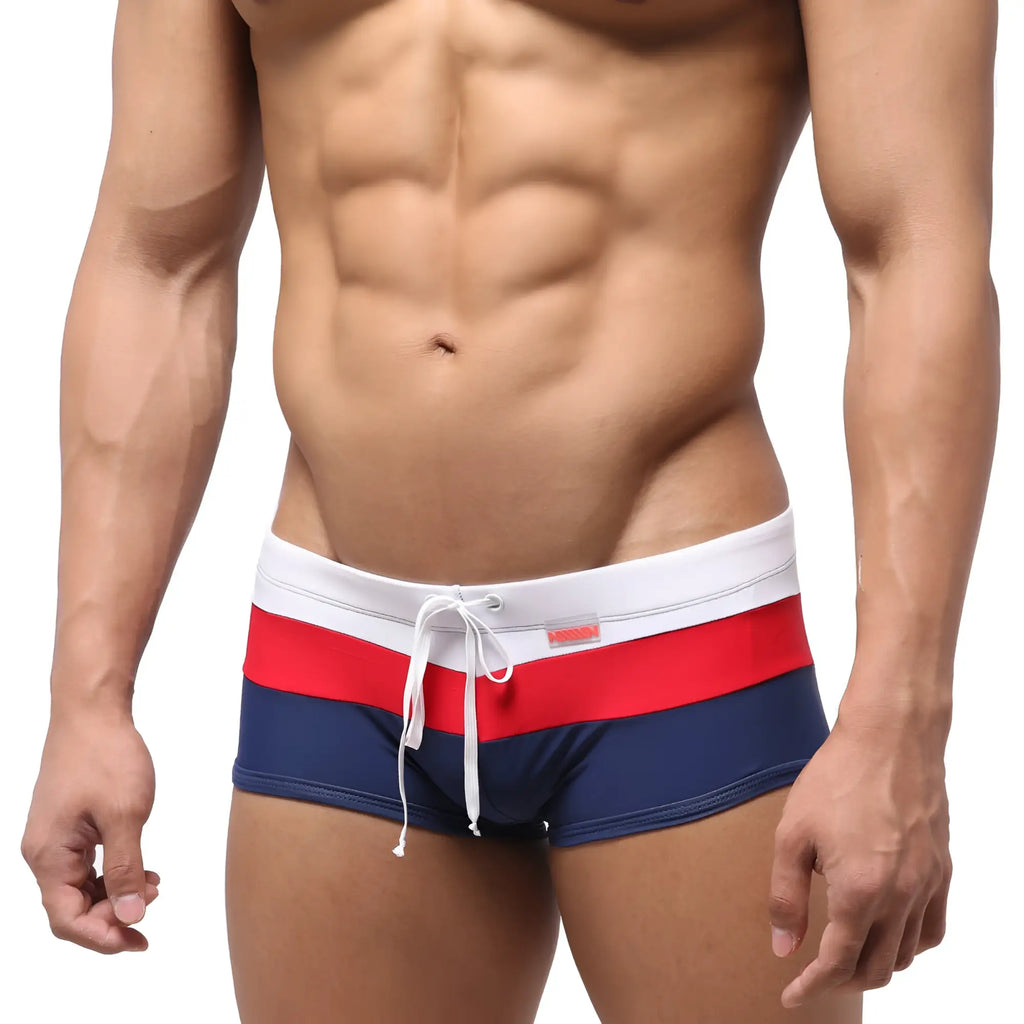 MetroMaleWear lycos swim trunk navy 4938-28 features navy blue fabric with bold red and white horizontal waistband stripes