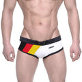 White swim trunks with black trim and bold german flag design on the side featuring ammy brand name metroMalewear