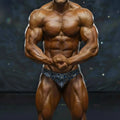 A muscular male bodybuilder wearing blue and white striped metro musclwear basic competition briefs for bodybuilding