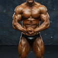 A muscular male bodybuilder wearing a sleek black latex brief metro musclwear basic competition suit leather 4974-74