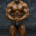 A muscular bodybuilder wearing black competition briefs with a silver white decorative belt from MetroMaleWear