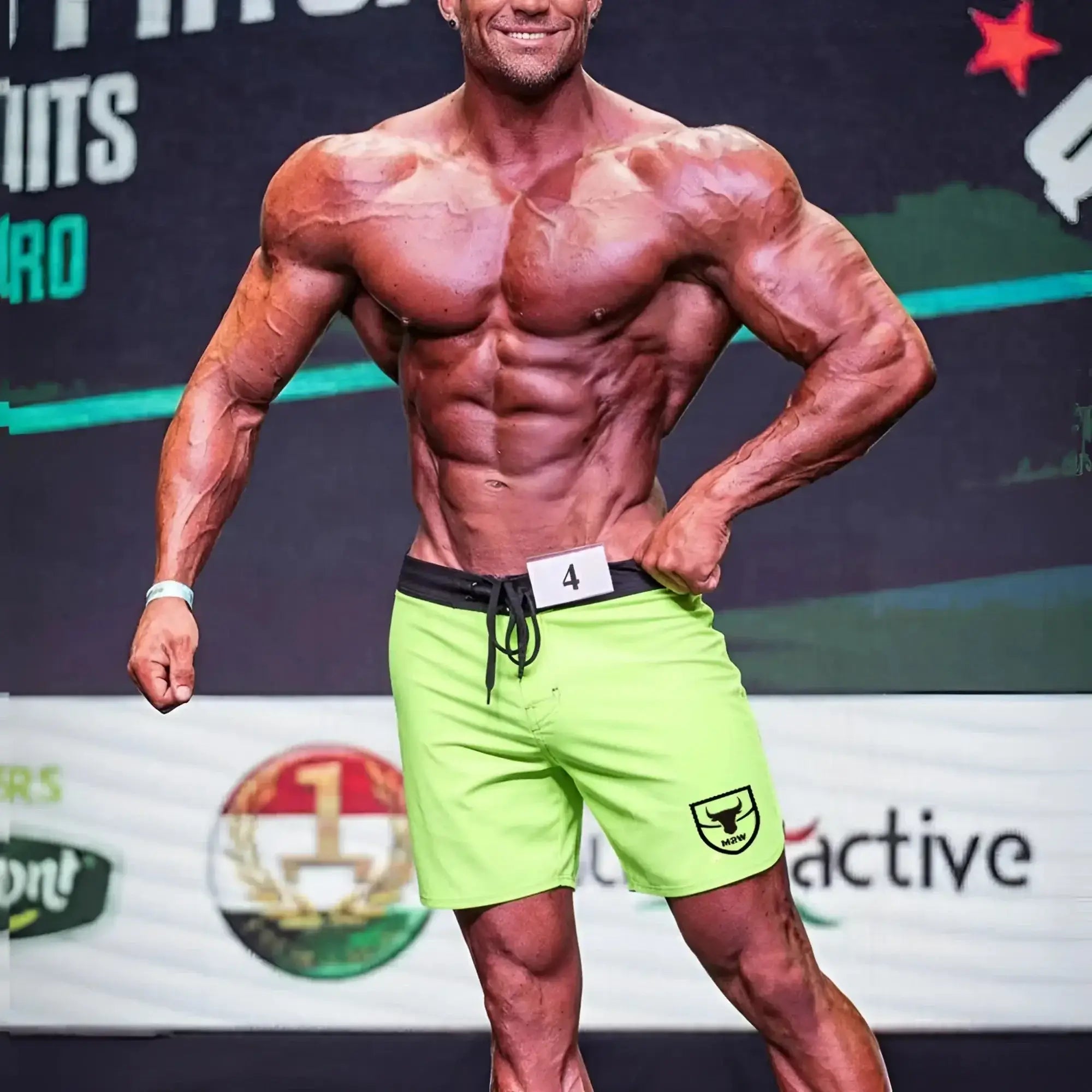 Bright neon green athletic shorts with black waistband and drawstring featuring small shield logo on left leg