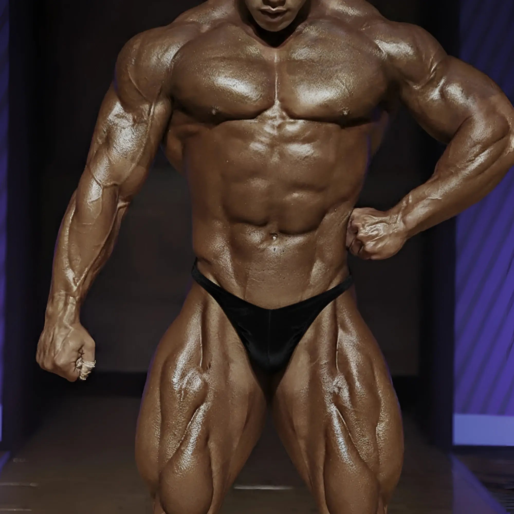 A muscular bodybuilder wearing the metro malewear posingwear ifbb pro posing suit black briefs showing back side