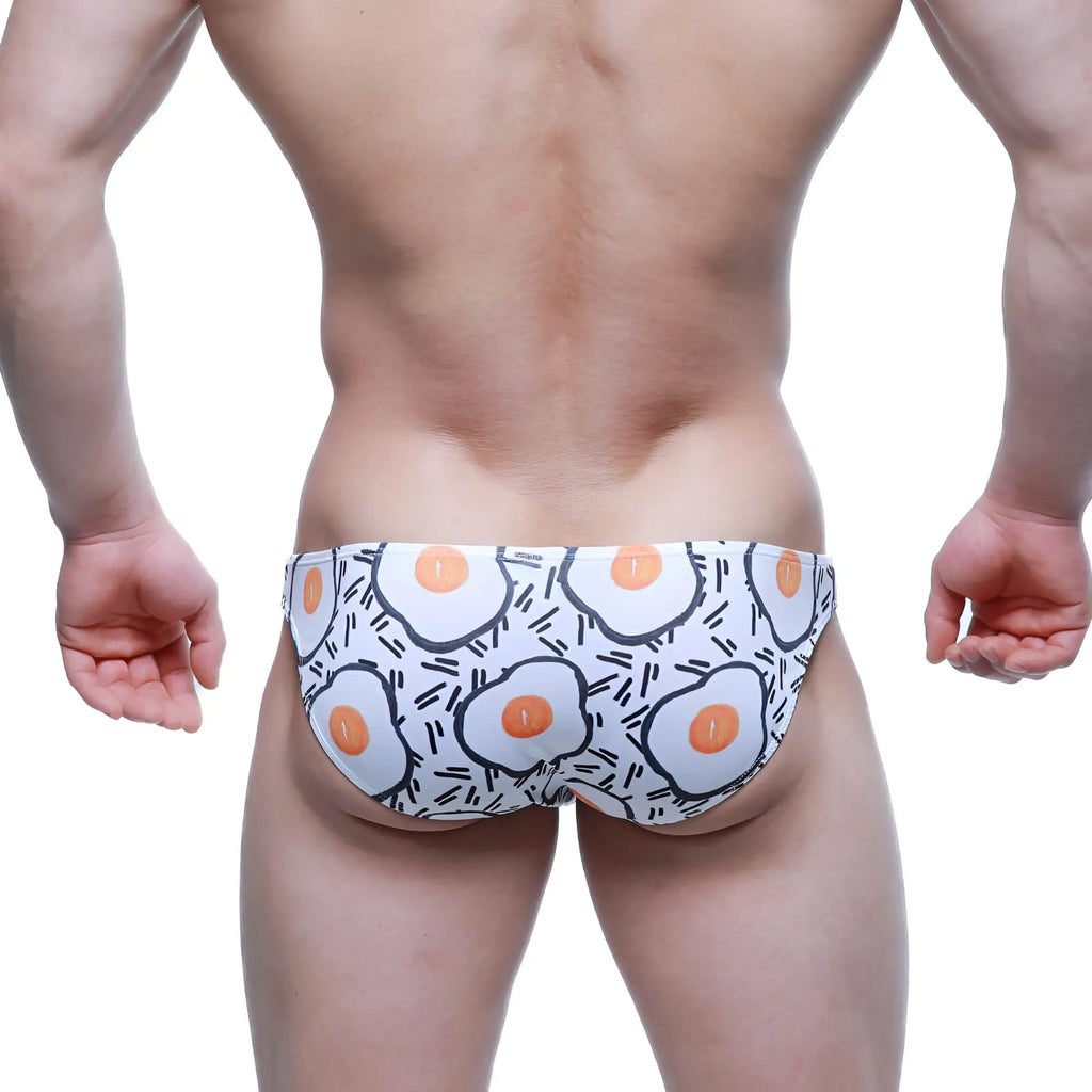 White swim trunks by metromalewear with playful fried egg pattern and black line accents sunny side lowrise bikini 6115-67