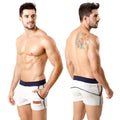 White terry sport shorts with navy waistband and trim featuring a small orange logo from metromalewear
