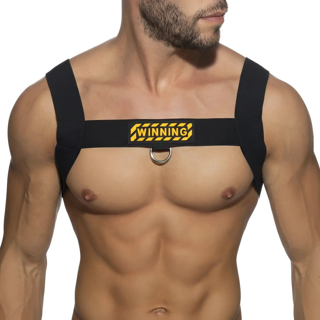 Black fabric shoulder harness with yellow winning logo patch and silver metal ring from metromalewear elastic body harness