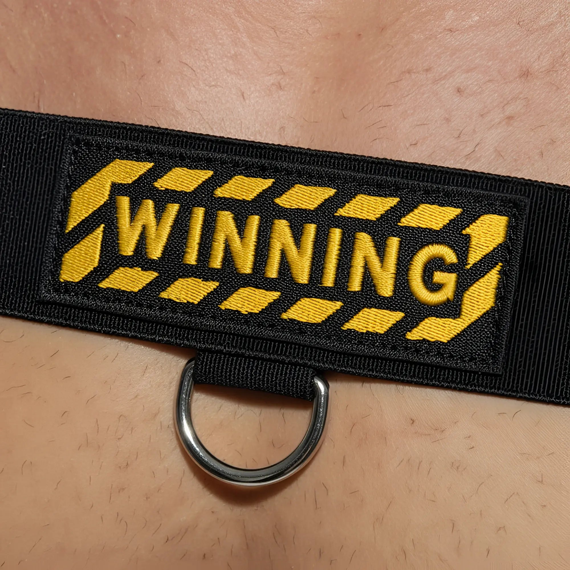 Black fabric strap body harness with yellow winning embroidery caution stripe and silver metal d ring by metromalewear