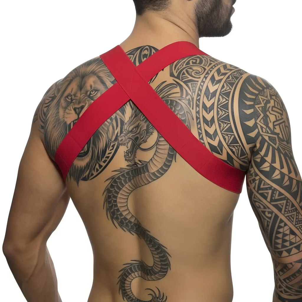 Red cross-back strap body harness in elastic material worn over tattooed shoulders showing back side view