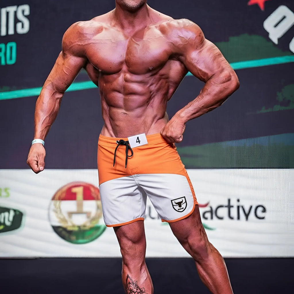 Orange and white MetroMaleWear MetroMuscleWear Cordoba physique board shorts with black drawstring and shield logo