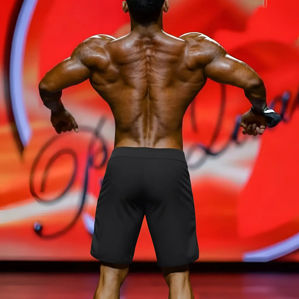 A muscular man shows defined shoulder blades wearing metro malewear metro musclewear ifbb pro mens physique board short colombia