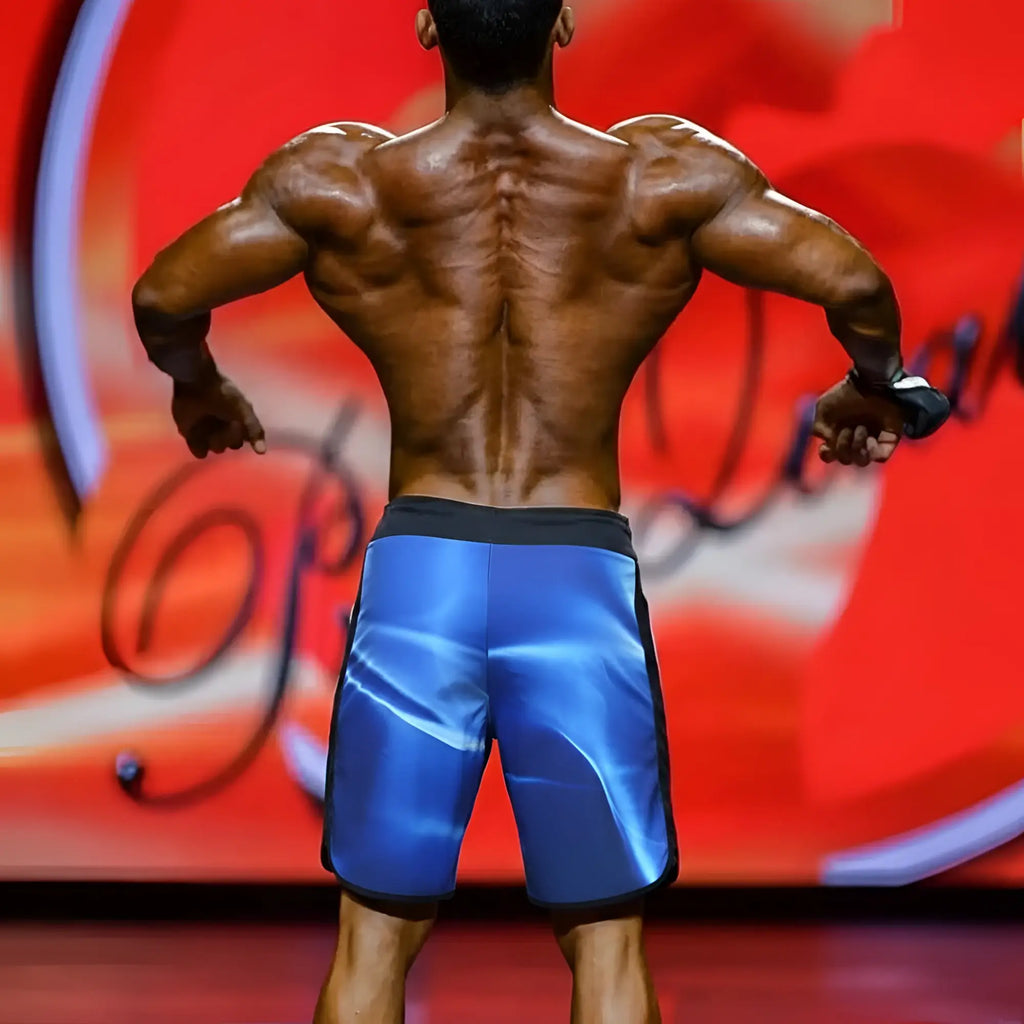 Blue athletic board shorts with glossy reflective finish and black trim from MetroMaleWear MetroMuscleWear IFBB Pro