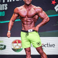 Bright neon green athletic shorts with black waistband and drawstring featuring small shield logo on left leg by metromalewear
