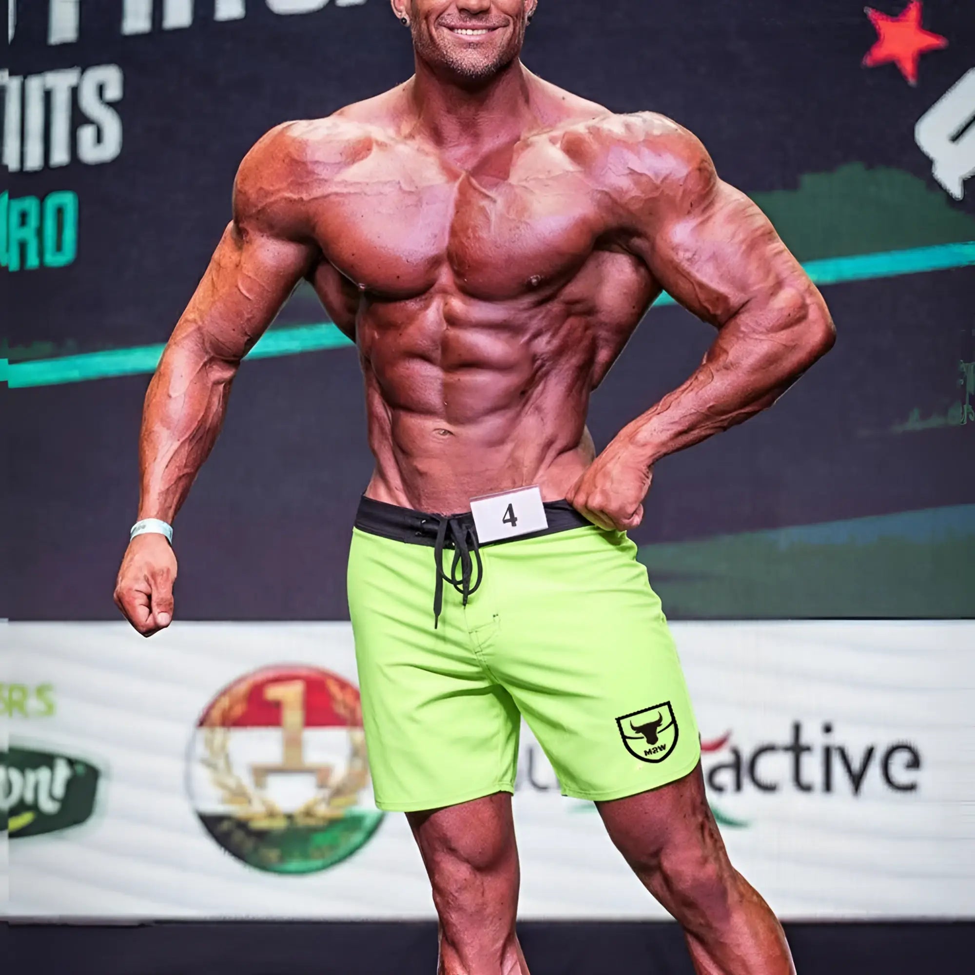 Bright neon green athletic shorts with black waistband and drawstring featuring small shield logo on left leg by metromalewear