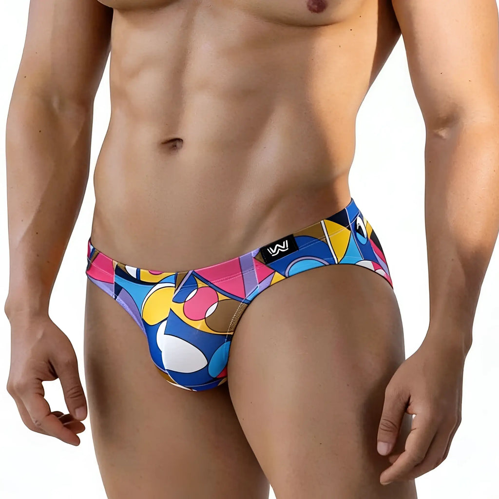 Vibrant geometric-patterned men’s swim trunks in blue pink yellow and white with black logo tag metroMalewear picasso bikini 5103-m87