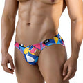 Vibrant geometric-patterned men’s swim trunks in blue pink yellow and white with black logo tag metroMalewear picasso bikini 5103-m87