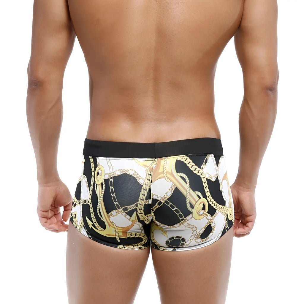 Black and white MetroMaleWear Profundo swim boxer briefs with bold gold anchor and chain pattern for luxury swimwear