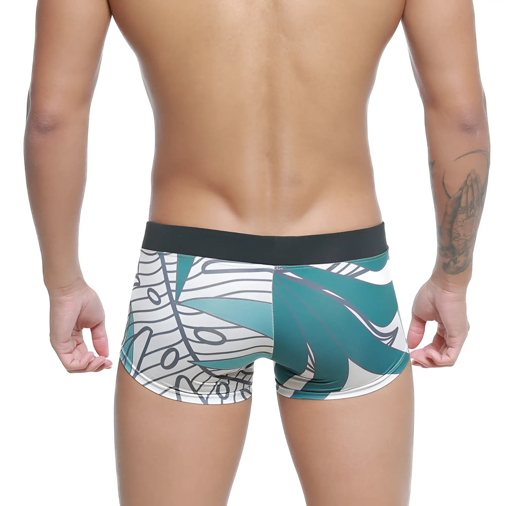 Teal and white tropical leaf-patterned men’s briefs with black elastic waistband from MetroMaleWear Profundo swim boxer briefs
