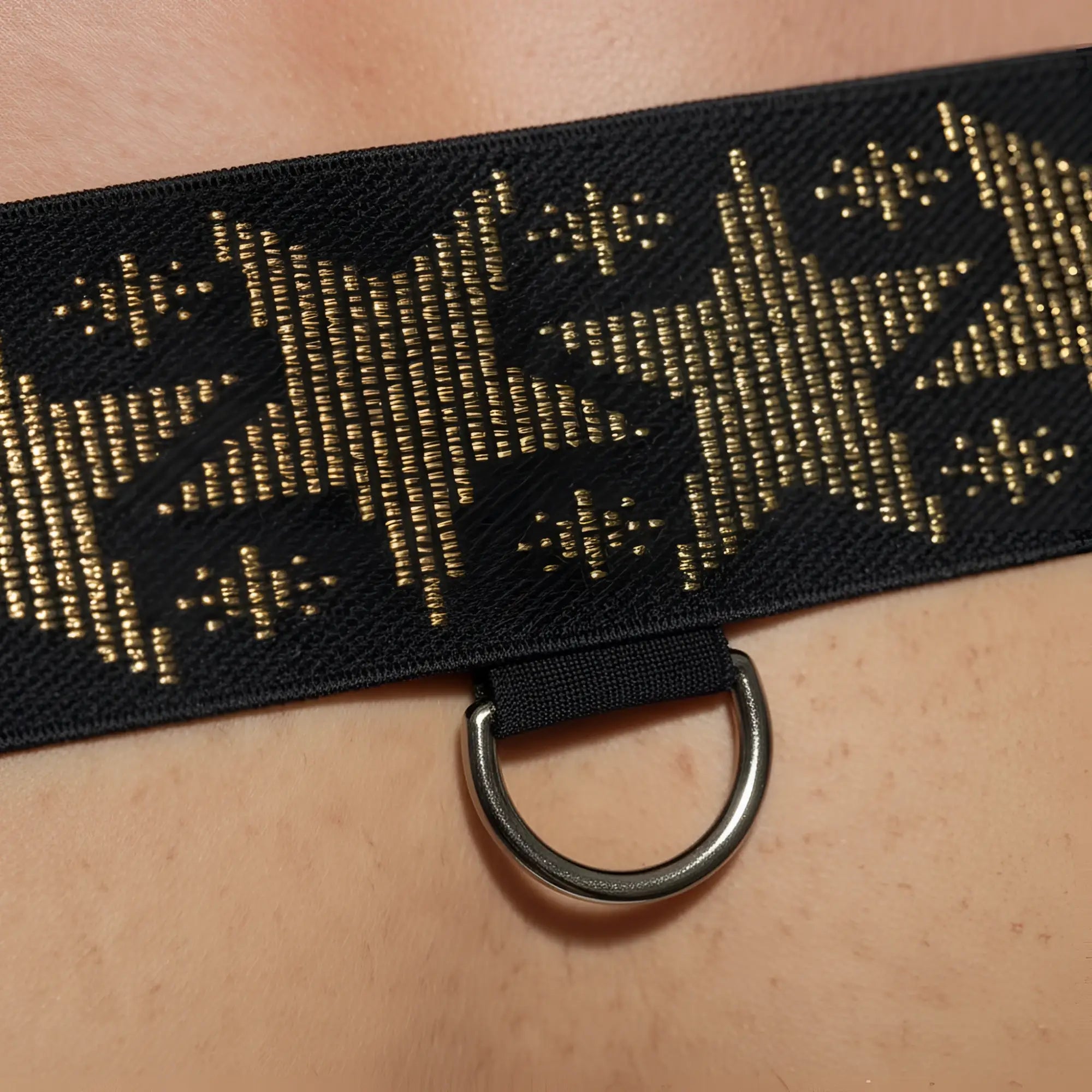 Black elastic strap harness by metromalewear with gold star patterns and metal d-ring for adjustable fit