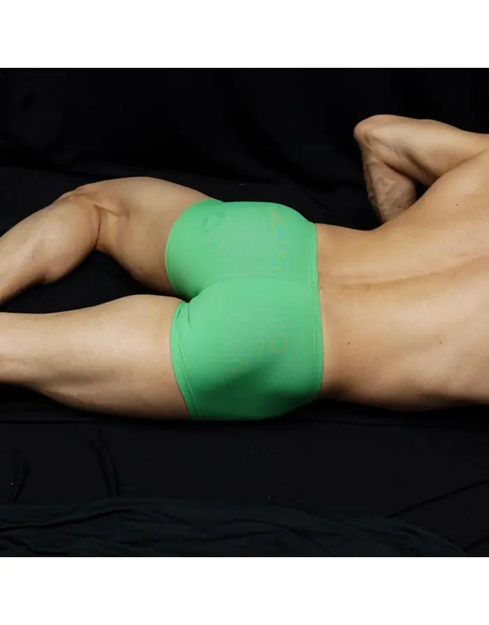 Green boxer underwear by Arroyman featuring a snug fit and smooth fabric shown on a model lying down.