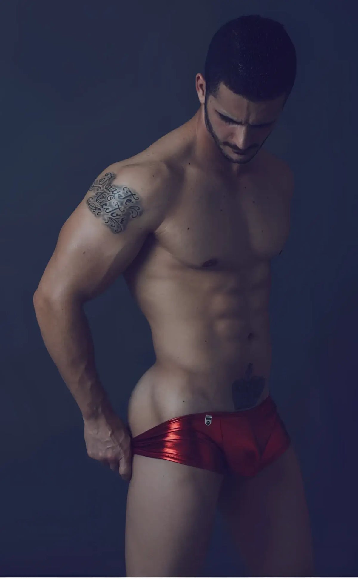 Shiny red metallic mob mirror boxer briefs with a small logo on the front in close-up view