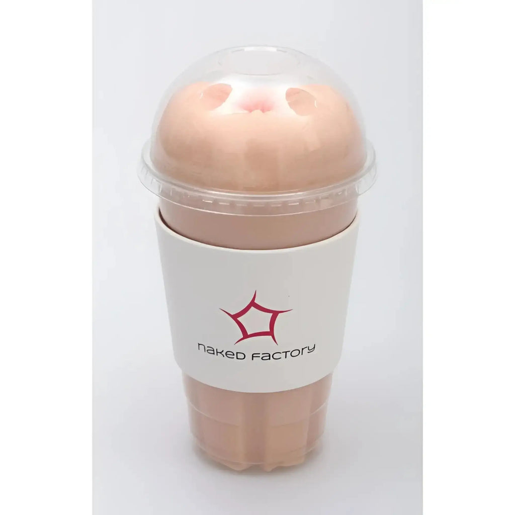 A peach-colored silicone anal masturbator resembling a cup with clear lid and white naked factory logo sleeve