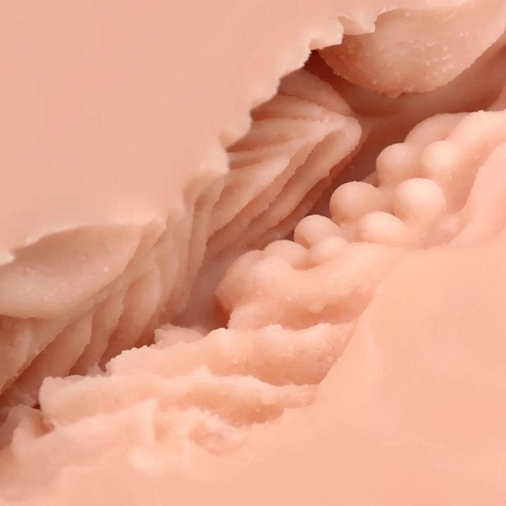 Pink silicone dildo with textured ridged surface and bead-like protrusions from naked factory pussy masturbator blair