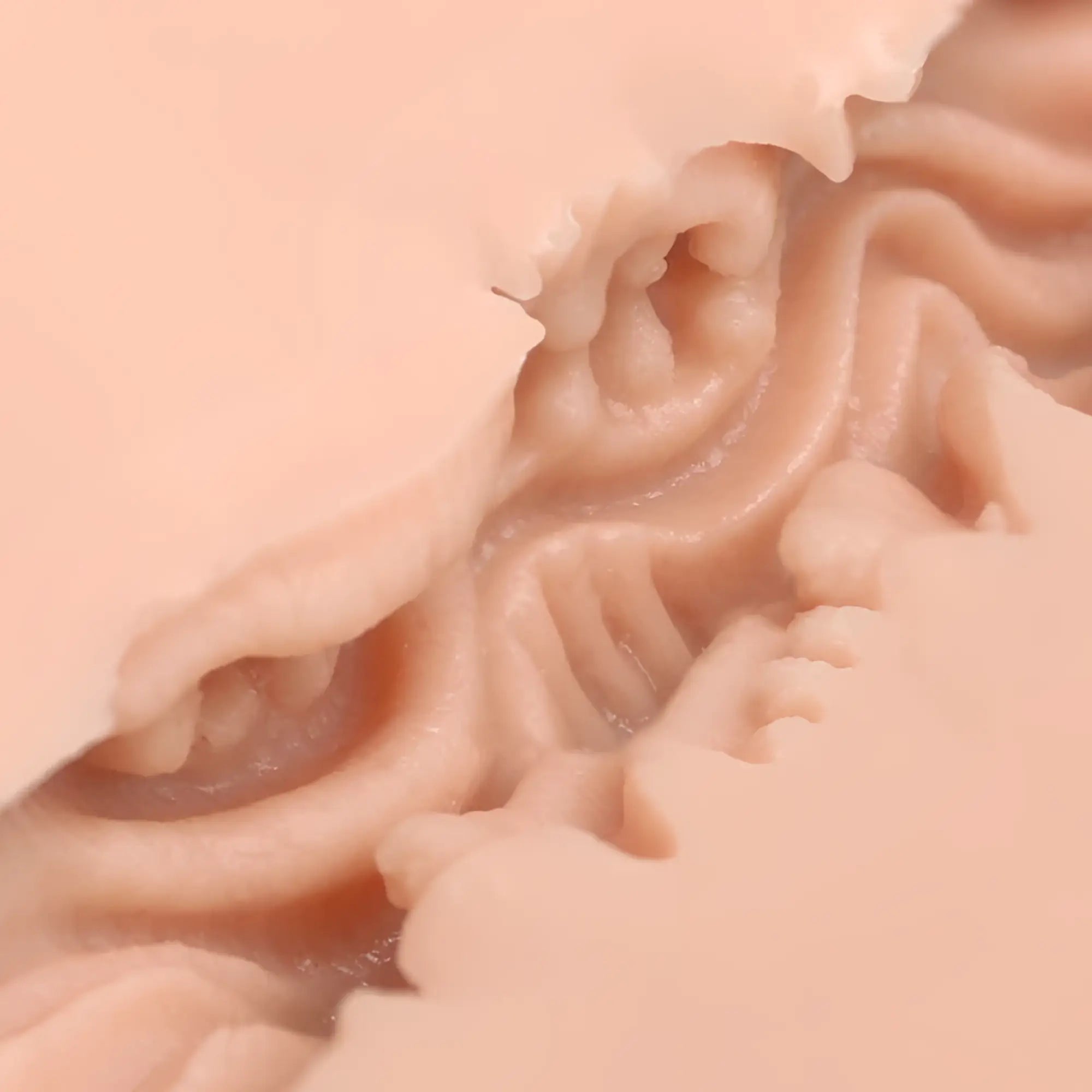 Peach-colored silicone mold with intricate wavy ridges and textured surface for naked factory pussy masturbator dani